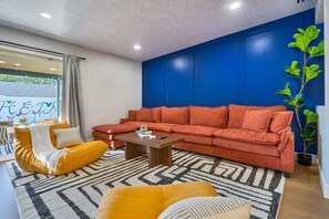 Ein Wohnzimmer mit einem roten Sofa, einem gelben Sessel und einem Couchtisch.