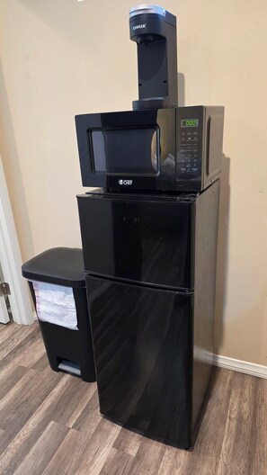A black commercial kitchen with a microwave, a coffee maker, and a trash bin. - Studio 2 - Comfortable Guest Studio by Cedars-Sinai, Beverly Hills (Beverly Hills)