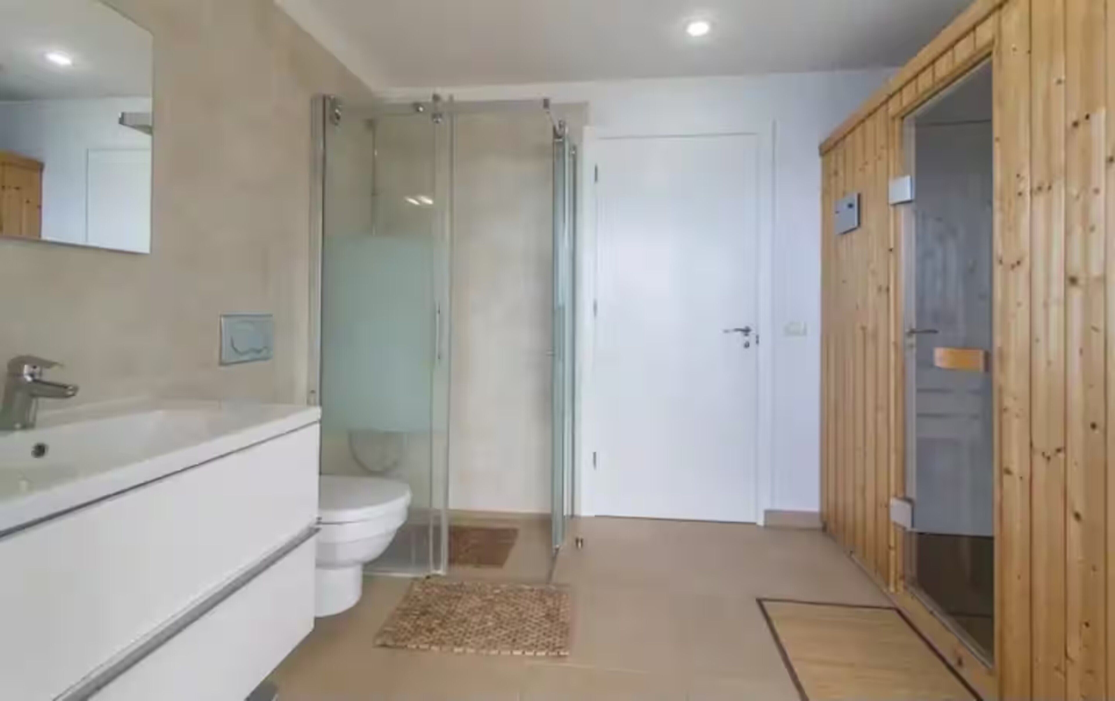 Ein Badezimmer mit Duschkabine, Toilette und Waschbecken.