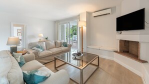 Ein modernes Wohnzimmer mit Sofa, Couchtisch und Fernseher.