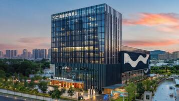 A modern hotel with a glass facade and a distinctive wave pattern on the side.