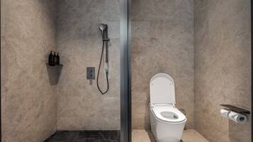 A bathroom with a shower, toilet, and a shelf with toiletries.