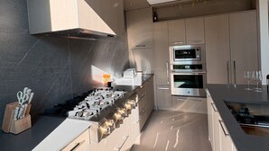 A modern kitchen with a gas stove, built-in oven, and stainless steel appliances. - 3-bedroom townhome with roof top patio - Gyro Beach across the street (Kelowna)