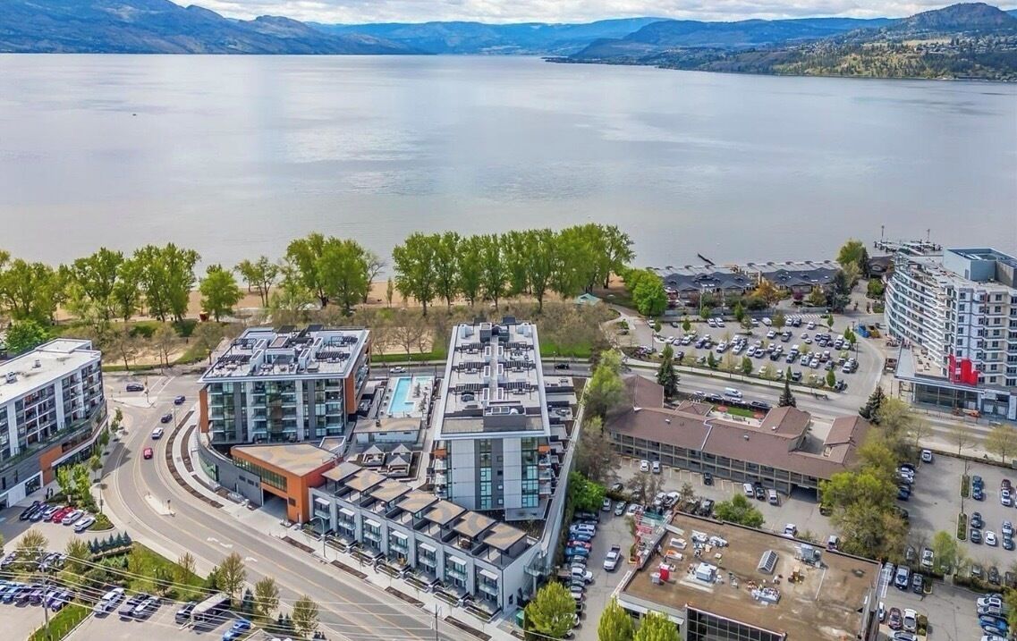 Et moderne hotelkompleks med flere bygninger, en swimmingpool og en parkeringsplads.