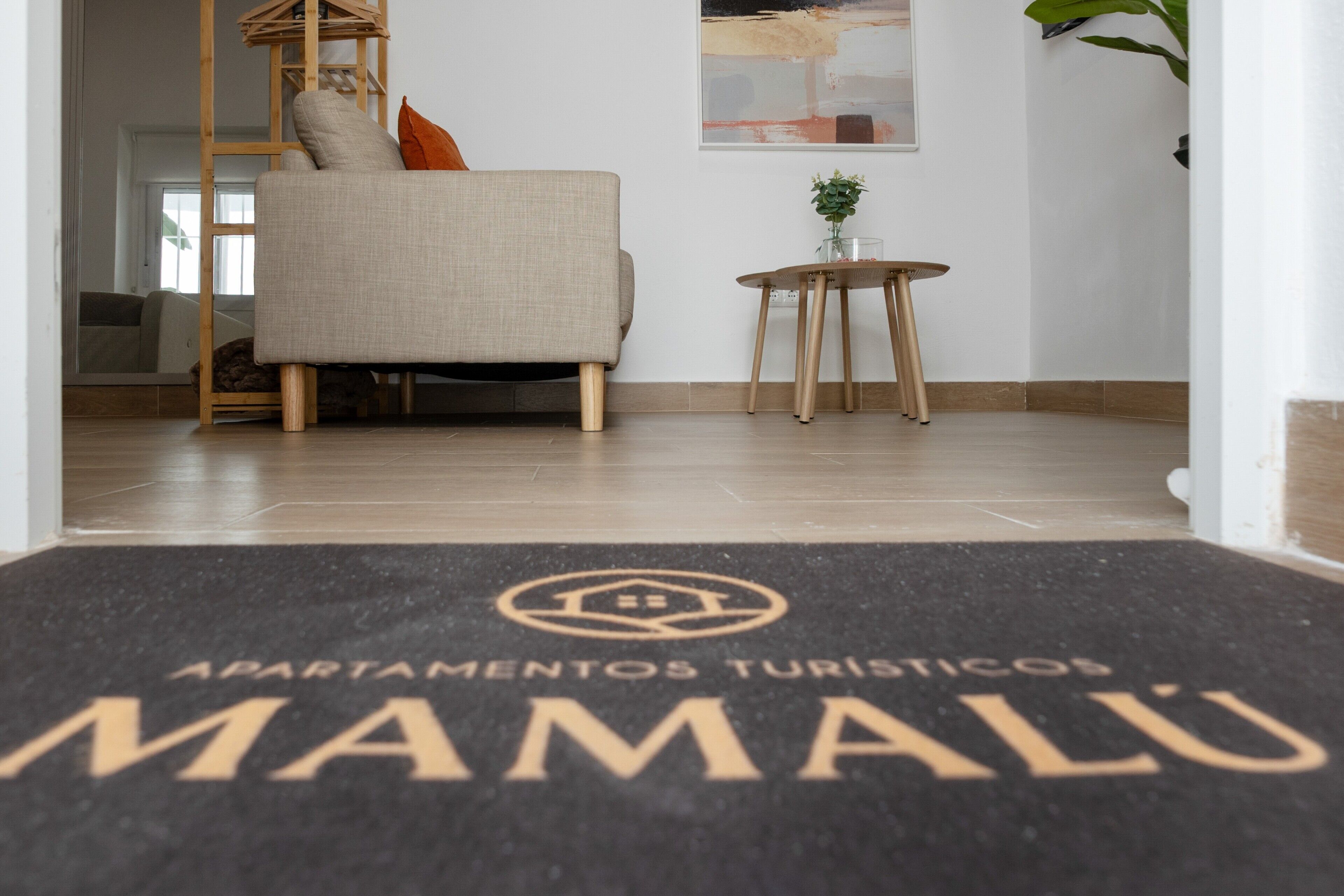 A hotel entrance with a doormat reading 'Apartamentos Turísticos Mamalu.'