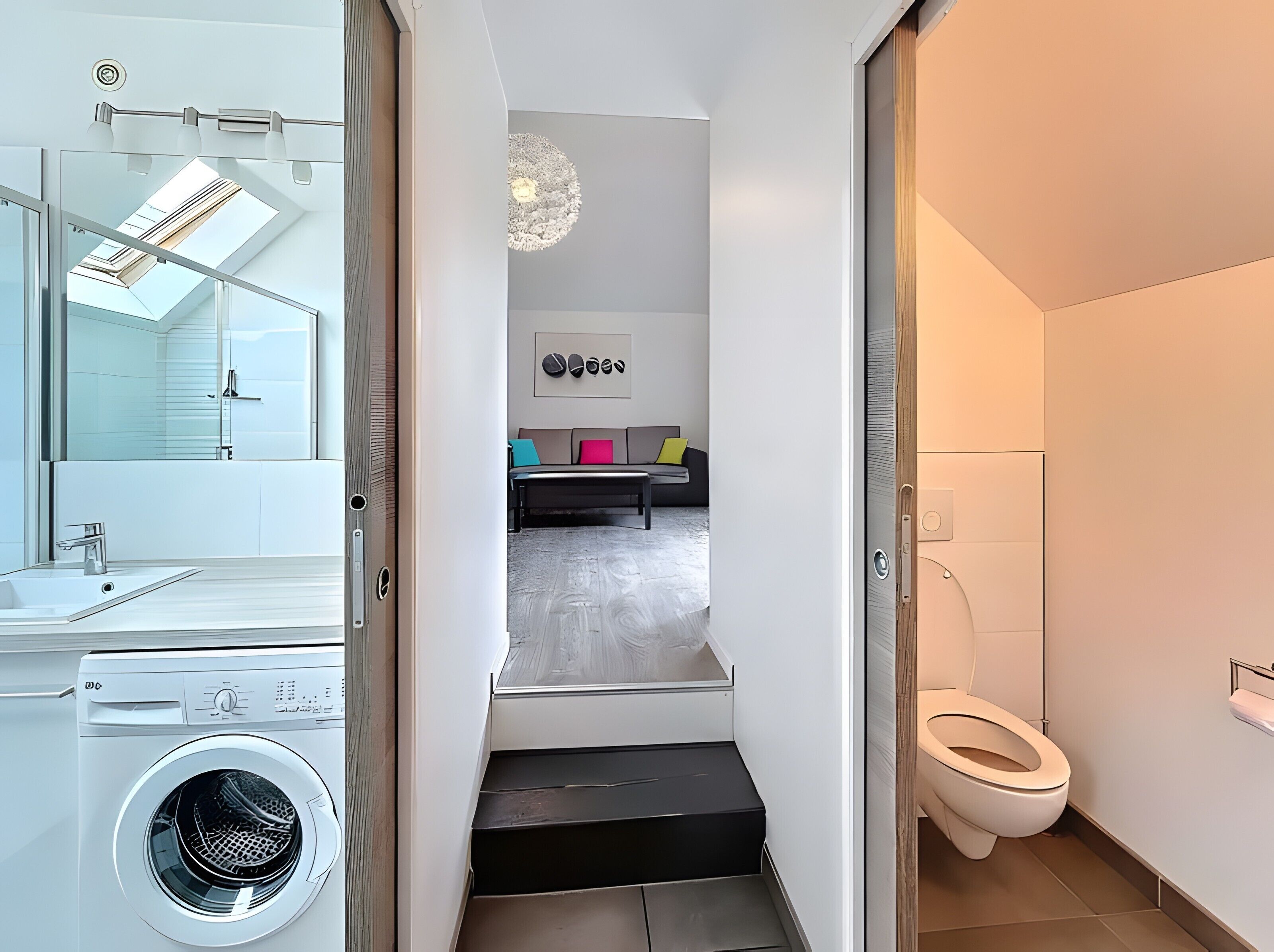 Un baño moderno con inodoro blanco, lavadora y cabina de ducha de vidrio.