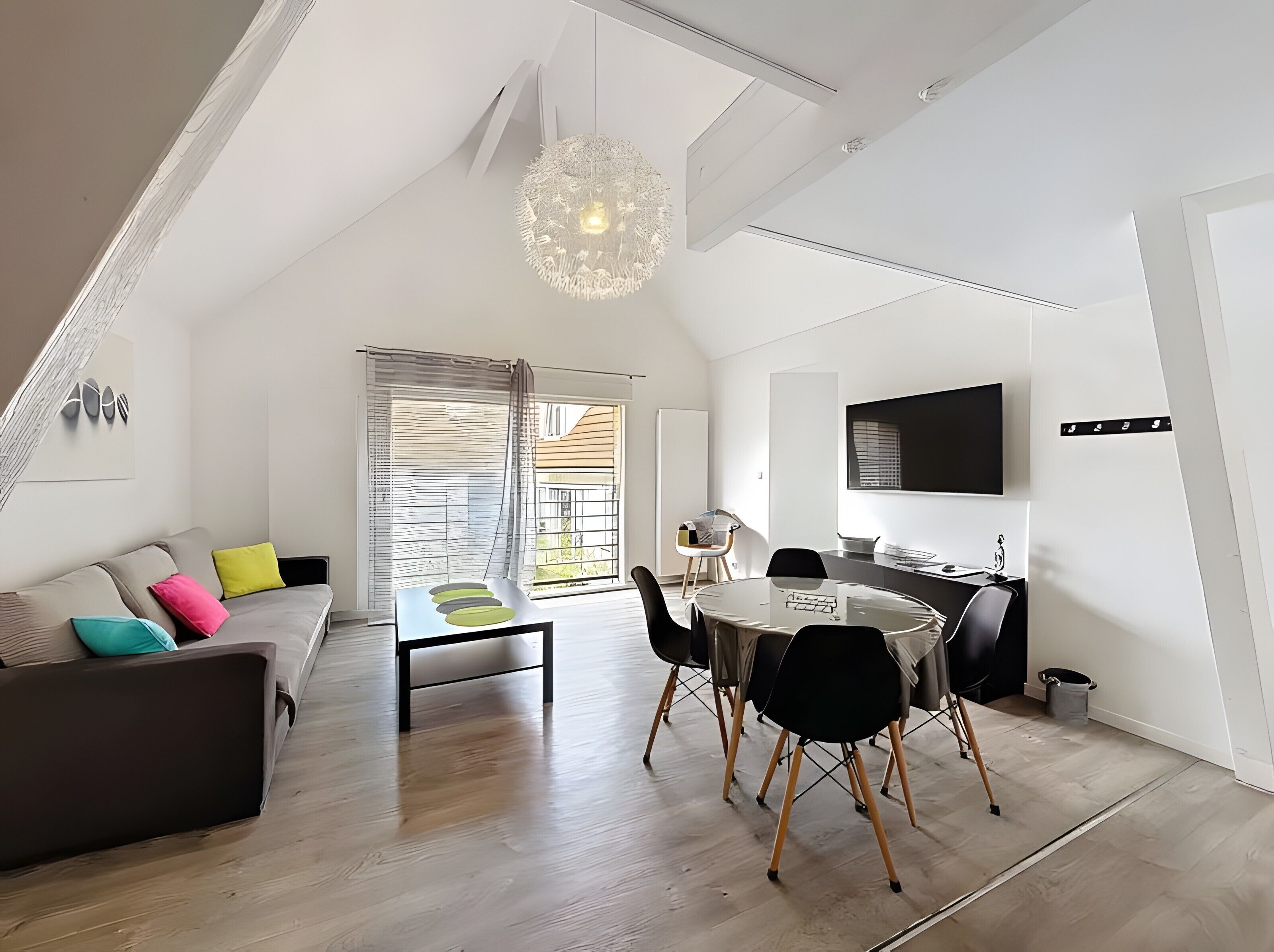 Een moderne woonruimte met een slaapkamer op entresol, een eethoek en een keuken.