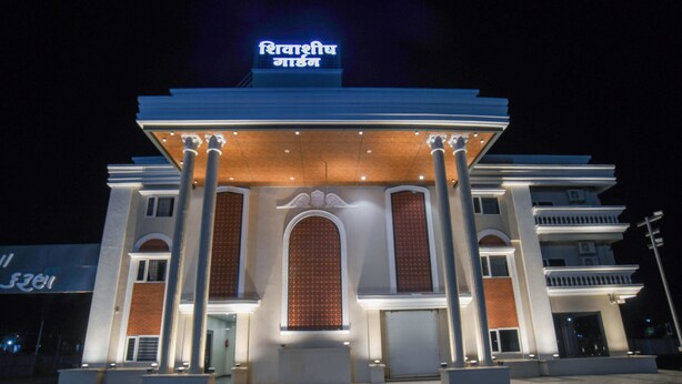 A hotel with a prominent entrance, large columns, and a sign with text. - Shivashish Resort and Marriage Garden (Indore)