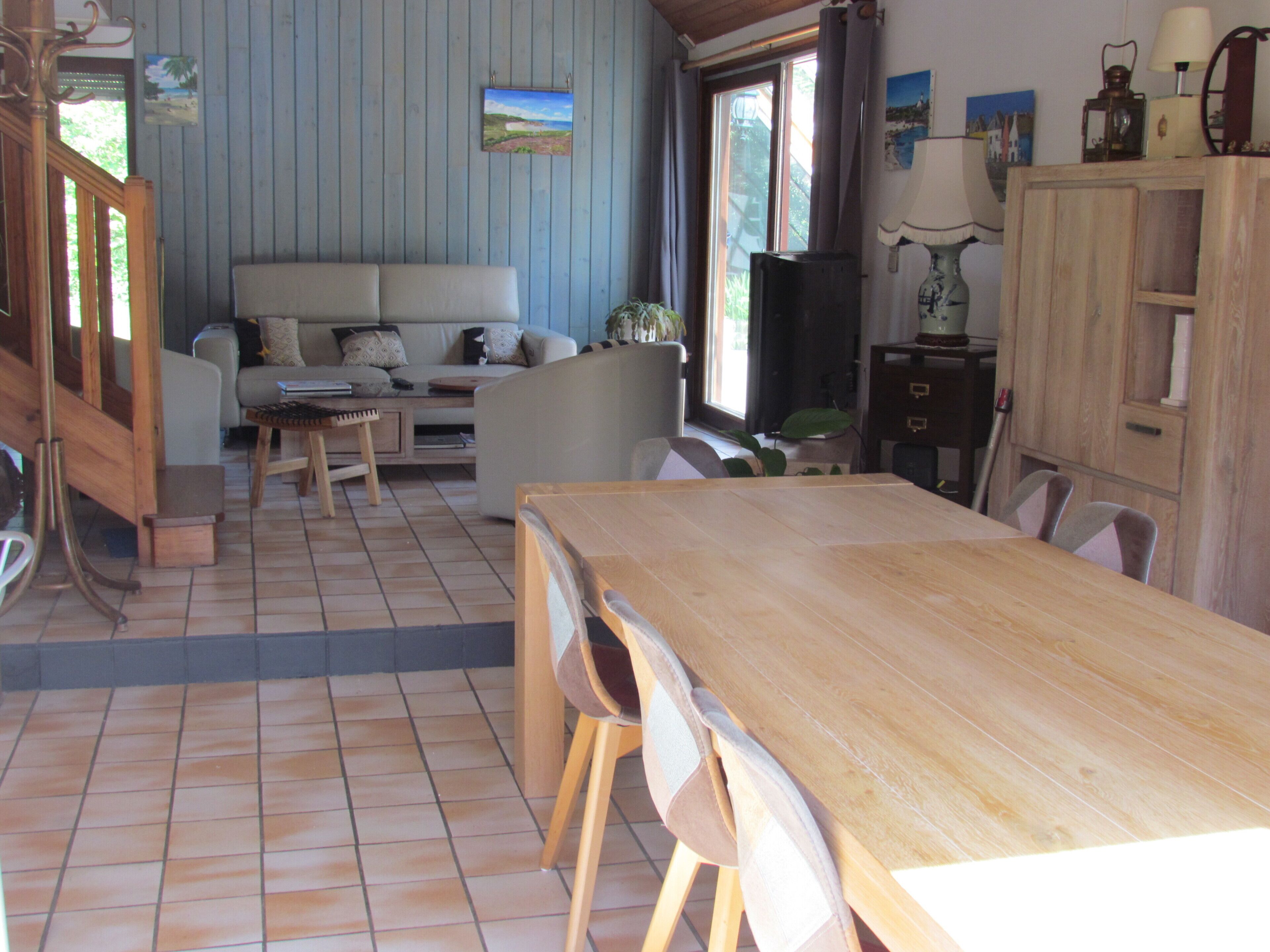 Ein Wohnzimmer mit einer Couch, einem Holzesstisch und Stühlen.