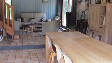 Ein Wohnzimmer mit einer Couch, einem Holzesstisch und Stühlen.
