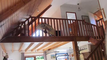 Ein geräumiger Innenraum mit einer Holztreppe, einem Essbereich und einer Küche.