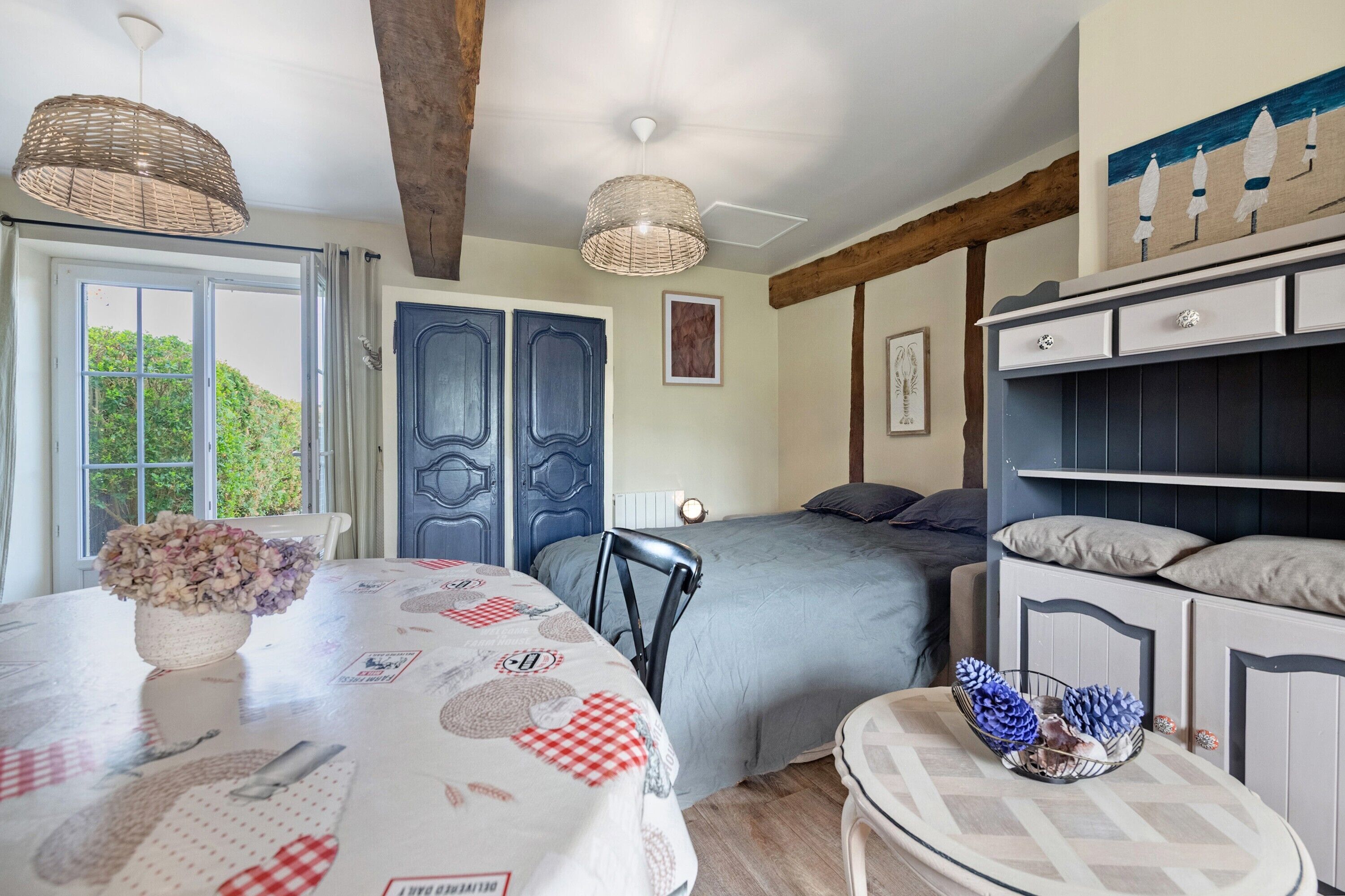 A bedroom with a bed, bedside tables, a window, and a door.