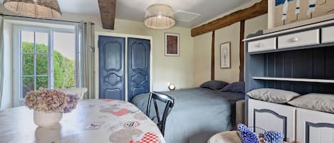 Un dormitorio con cama, mesitas de noche, ventana y puerta.