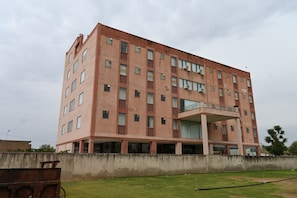 Un edificio de varios pisos con techo plano, ventanas rectangulares y una entrada central con balcón.