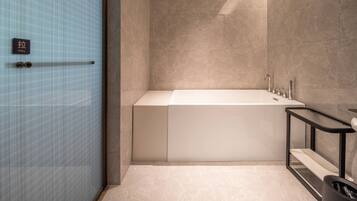 Un baño moderno con bañera, lavamanos e inodoro.