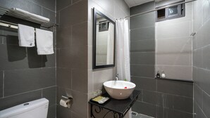 A modern bathroom with a toilet, a sink with a mirror, and a shower area. - Old Lane Hoi An Homestay (Hoi An)