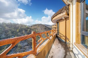 Ein Balkon mit Holzgeländer mit Blick auf eine Berglandschaft.