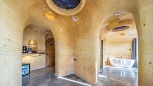 A modern interior with a large bathtub, a kitchen area, and a unique ceiling design. - 1168 Starry Sky Astronomy Hotel (Huzhou)
