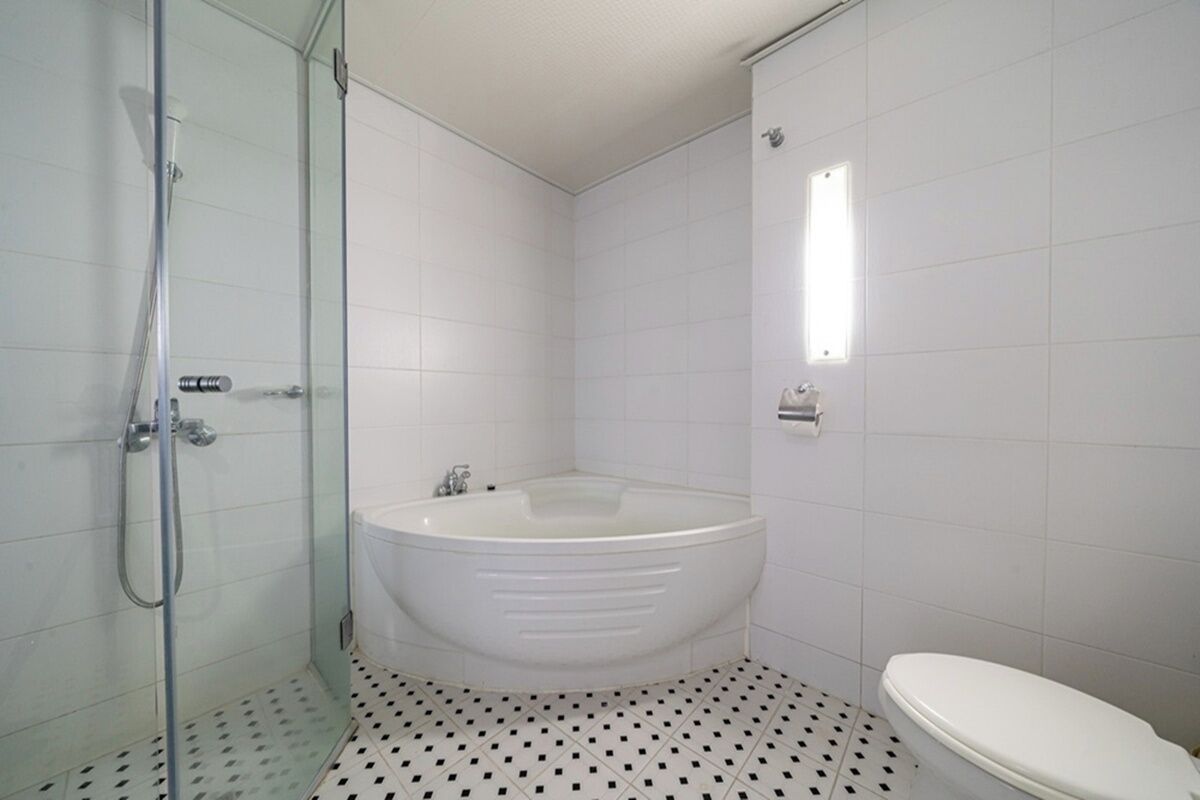 Ein Badezimmer mit Duschkabine aus Glas, freistehender Badewanne und Toilette.