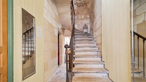 A staircase with stone steps and a metal handrail, leading to a room with a wooden door and a window. - Bed and Breakfast 'Le Studio Miroir Aux Fées Bordeaux' with Wi-Fi (Bordeaux)