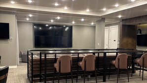 A conference room with a long table, multiple chairs, a large screen, and recessed ceiling lighting. - Luxury/Cozy 1-Bedroom Condo Retreat Dunwoody GA (Dunwoody)