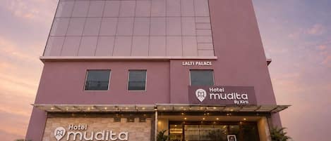 Egy szállodai épület, amelyen a „Hotel Mudita By Kirti” feliratú tábla található, és felette egy „LALTI PALACE” feliratú tábla.