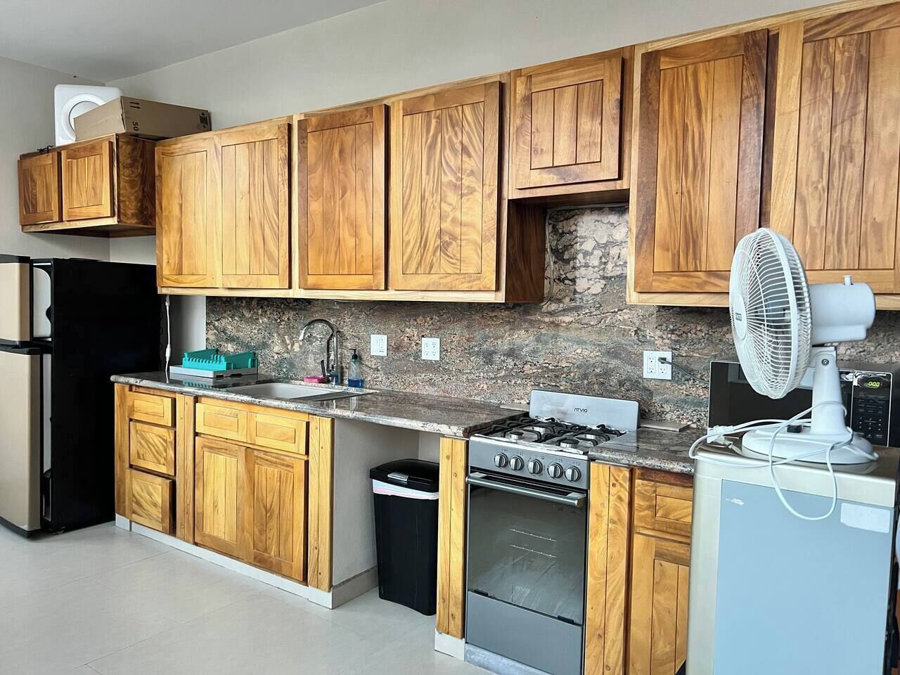 A kitchen with wooden cabinets, a gas stove, a dishwasher, and a microwave.