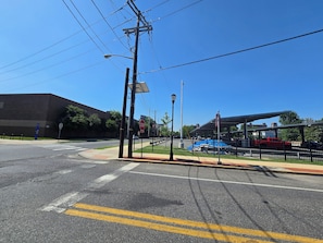 A street intersection with a pedestrian crossing, a stop sign, and a blue building in the background. - Lovely Studio Apartment Near Philadelphia (Camden)