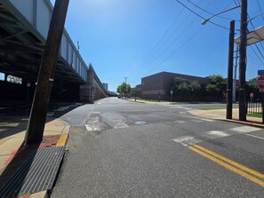 A street with a pedestrian crossing, a stop sign, and a building in the background. - Lovely Studio Apartment Near Philadelphia (Camden)