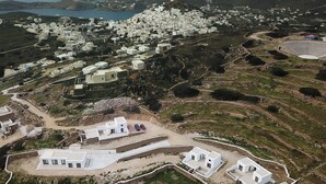A coastal village with white buildings, a stadium, and a road.