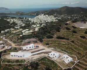 A coastal village with white buildings, a stadium, and a road. - Serenity Villas (ios)