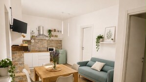 A modern living space with a dining area, a kitchen, and a seating area.