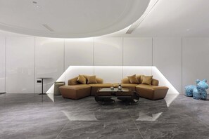 A modern living room with a sectional sofa, a glass coffee table, and a small side table.