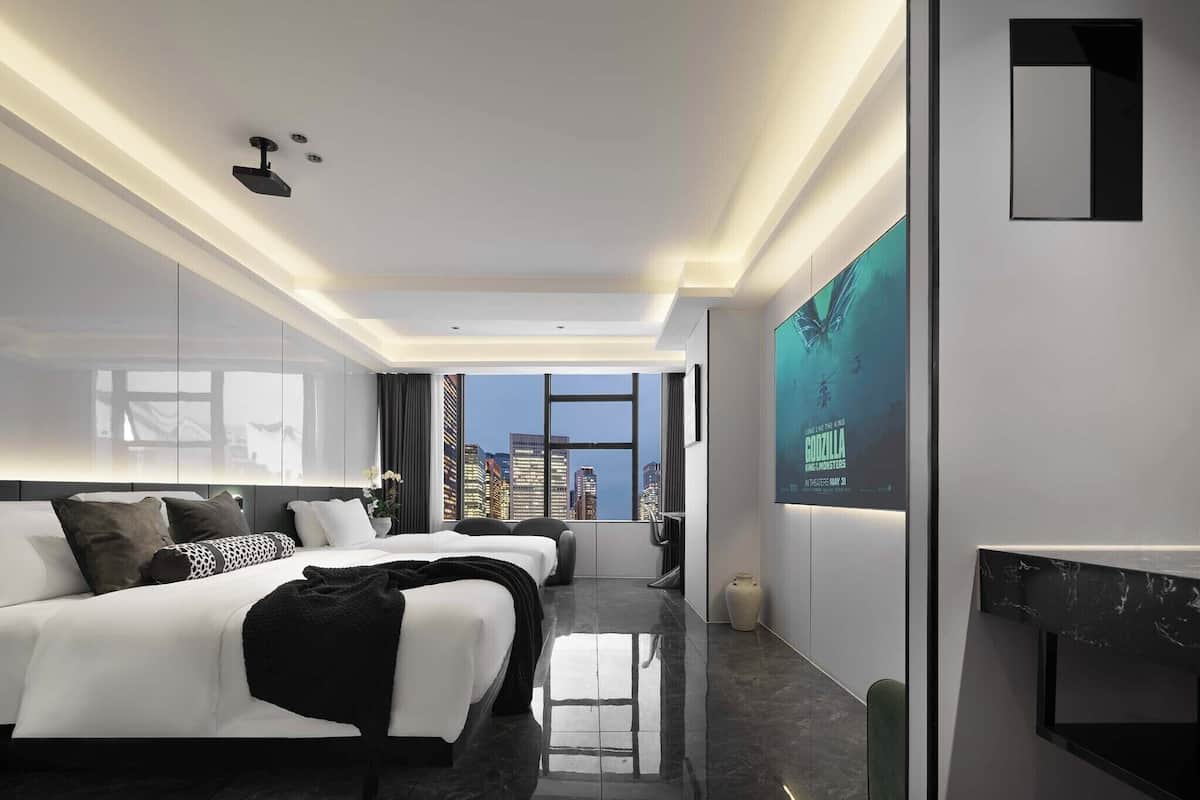Une chambre d’hôtel moderne avec un grand lit, un bureau et une vue sur la ville.