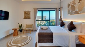 A modern hotel room with a large bed, a TV, a view of the city, and a ceiling light. - Villa Omara - Nusa Dua (Nusa Dua)