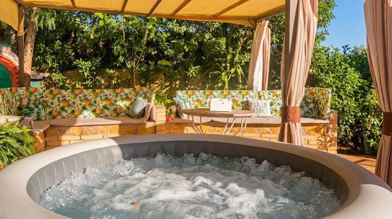 Een hottub met een stenen omlijsting, buiten zitplaatsen en een overdekt gedeelte met uitzicht op groen.