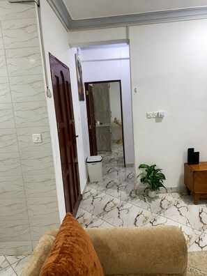 Una sala de estar con un sofá, una planta en maceta y una mesita de madera.