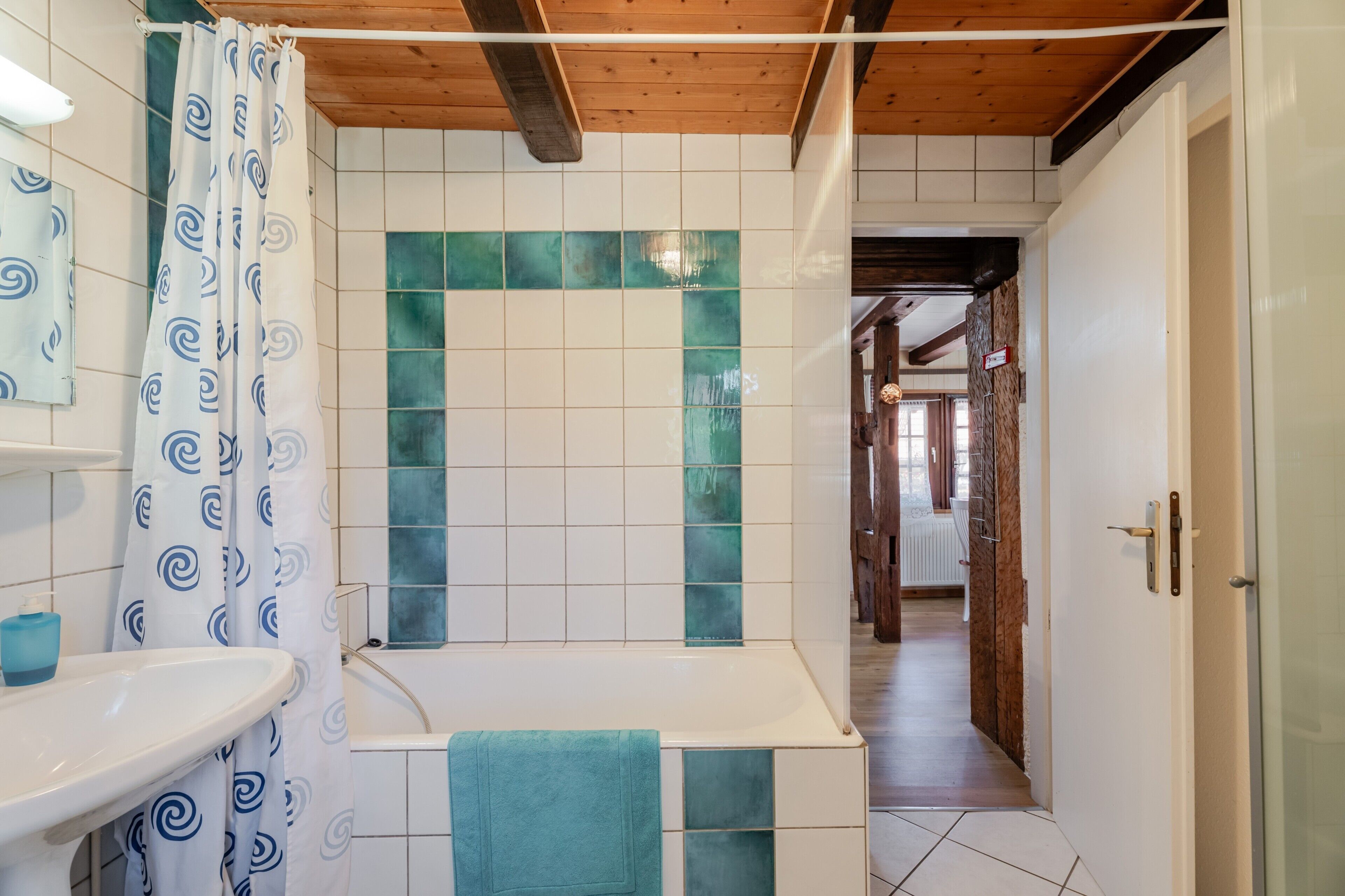 Ein Badezimmer mit Waschbecken, Badewanne und Duschvorhang.
