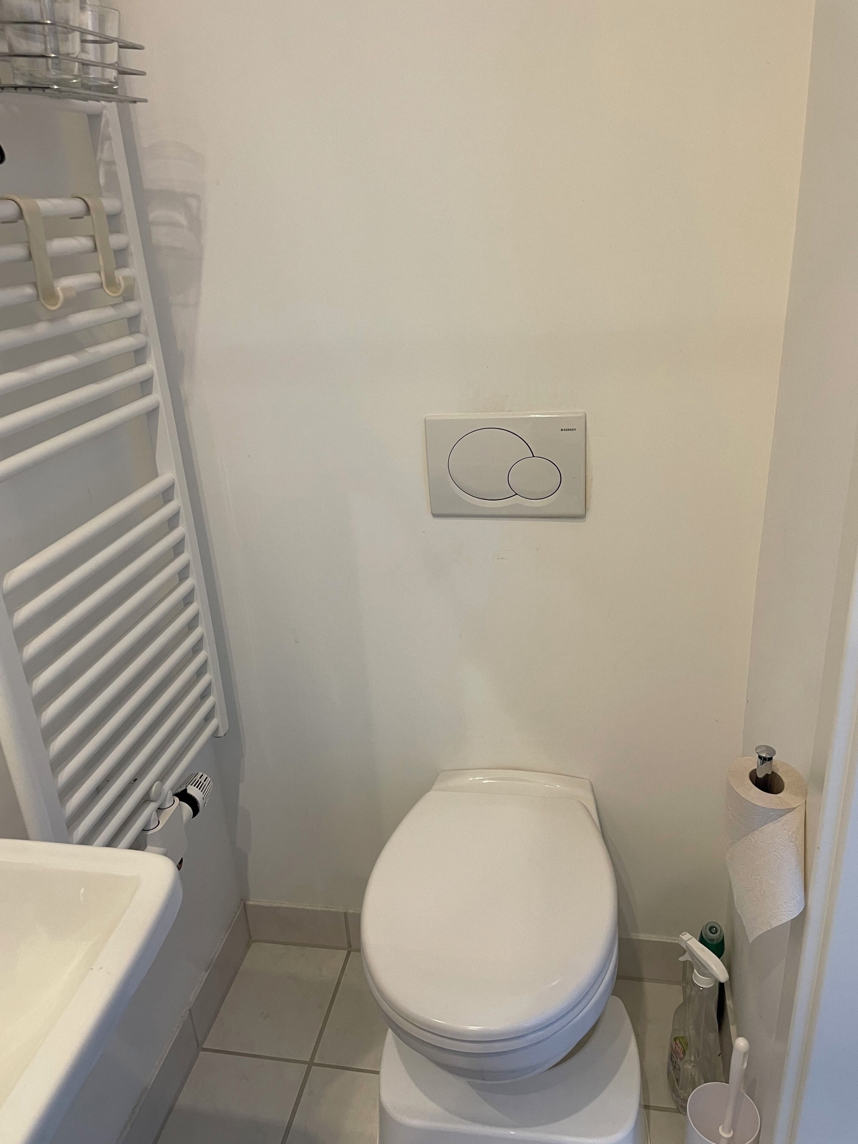 Ein Badezimmer mit Toilette, Heizkörper und Waschbecken.