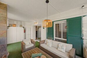 A living room with a sofa, chairs, a coffee table, and a hanging light fixture. - Apartment 'Reserva Del Higuerón' with Sea View, Wi-Fi and Air Conditioning (Fuengirola)