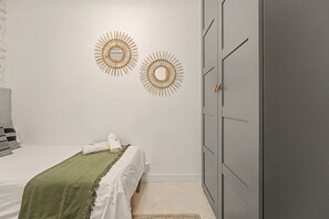 Ein Schlafzimmer mit einem Bett, einem Kleiderschrank und zwei Wanddekorationen.