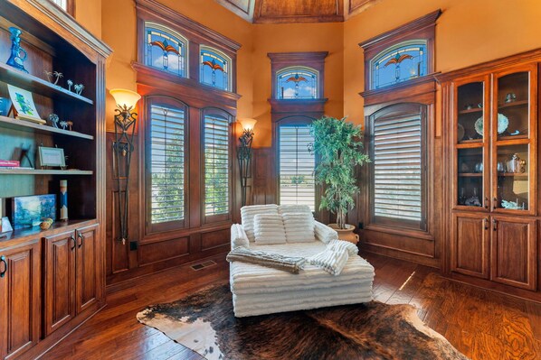 A room with a large bed, wooden cabinets, and a window with shutters.