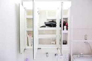 Ein Badezimmer mit einem weißen Waschbecken, einem Spiegel und einem Handtuchhalter.
