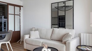 Una sala moderna con un sofá, una mesa de comedor y una mesita auxiliar.