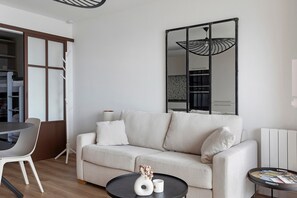 Una sala moderna con un sofá, una mesa de comedor y una mesita auxiliar.
