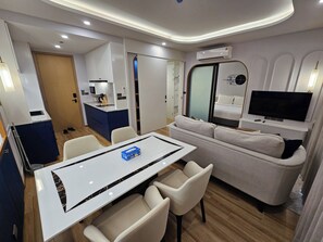 Ett modernt hotellrum med en matplats, en soffa, en TV och en luftkonditioneringsanläggning.