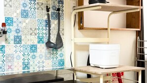 A kitchen with a tiled backsplash, a coffee maker on a shelf, a printer on a counter, and a fire extinguisher. - (千本南)Doraemon House in Osaka | 4 Min to Subway | Tea Room | Easy Airport Access (Osaka)