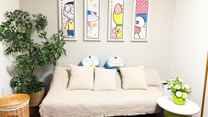 A bedroom with a bed, pillows, a wall-mounted air conditioner, and four framed pictures. - (千本南)Doraemon House in Osaka | 4 Min to Subway | Tea Room | Easy Airport Access (Osaka)