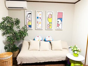 A bedroom with a bed, pillows, a wall-mounted air conditioner, and four framed pictures. - (千本南)Doraemon House in Osaka | 4 Min to Subway | Tea Room | Easy Airport Access (Osaka)