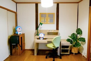 A room with a wooden desk, a green chair, a lamp, a potted plant, and a shelf with figurines. - (千本南)Doraemon House in Osaka | 4 Min to Subway | Tea Room | Easy Airport Access (Osaka)